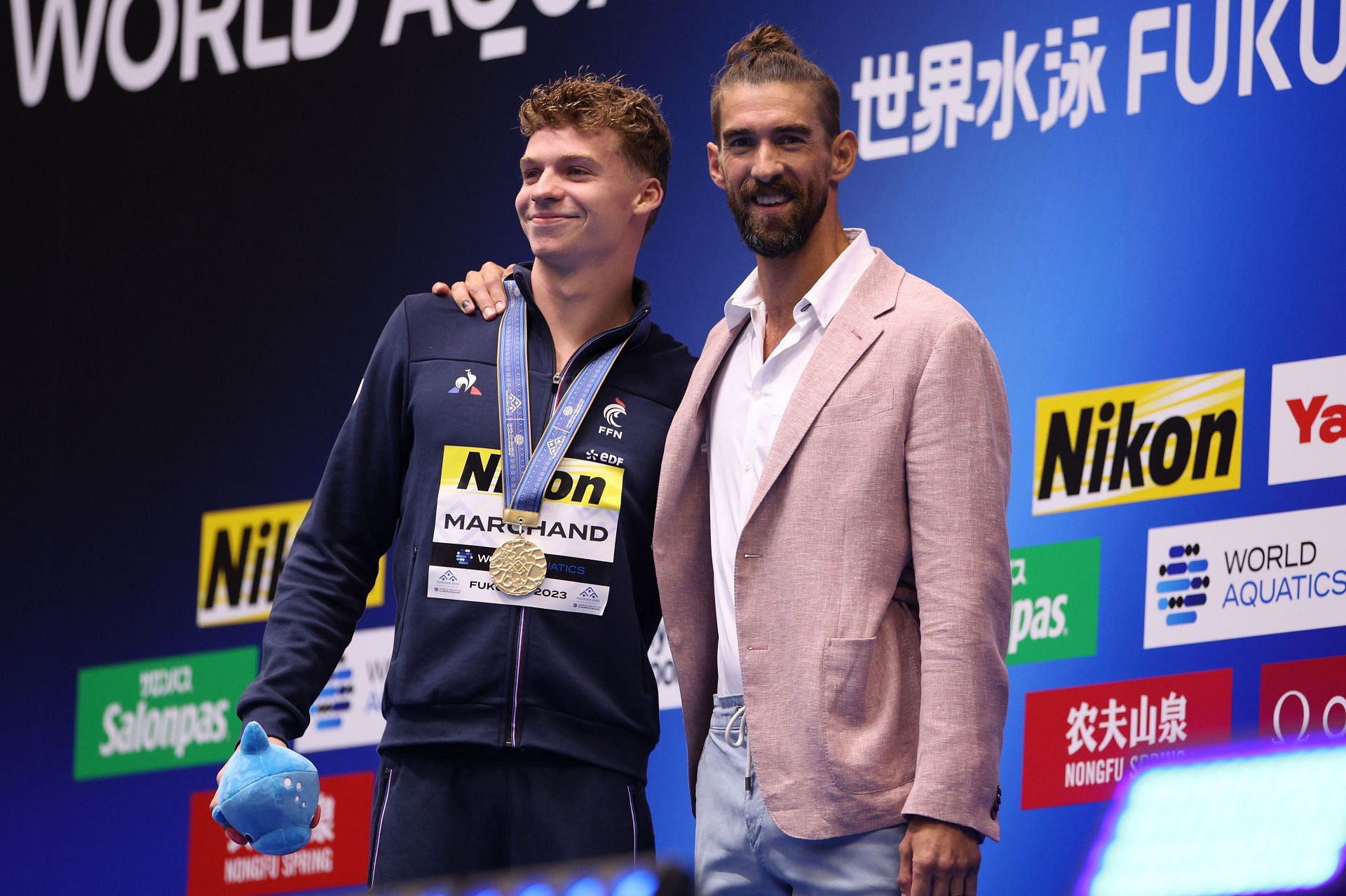 Leon Marchand of Team France is congratulated by Michael Phelps during the 2023 World Aquatics Championships - Source: Getty